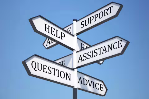 A wooden street sign with arrows pointing different directions labeled "help", "support", "assistance", "question", and "advice".